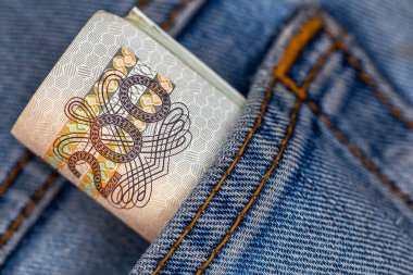 Bir sürü Polonyalı 200 'lük banknot kot pantolonun arka cebinden sarkmış. Fotoğraf yapay, yumuşak ışık altında çekildi