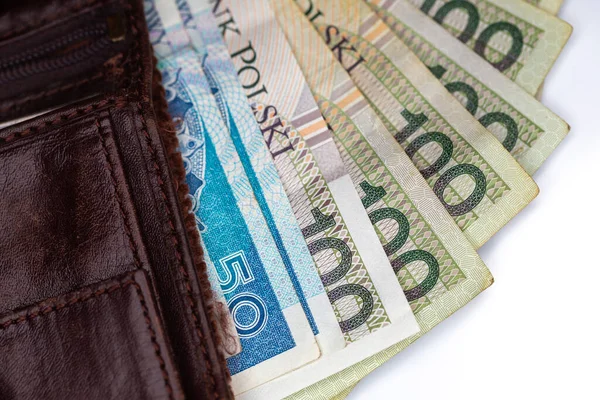 Kahverengi deri bir cüzdana yapışmış bir sürü Polonyalı banknot. Fotoğraf yapay, yumuşak ışık altında çekildi, objec beyaz arka planda izole edildi