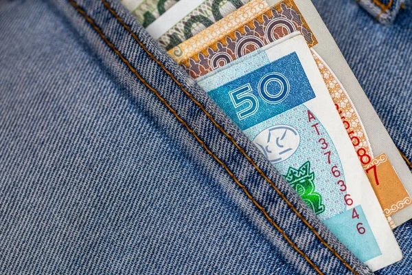 Lots of Polish bills sticking out of the back pocket of denim pants. Photo taken under artificial, soft light