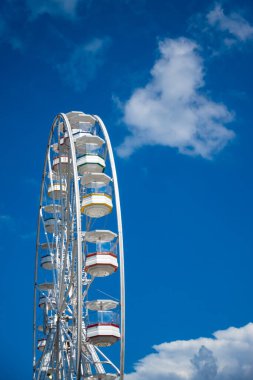 Mavi bir arka planda beyaz bir dönme dolap. Fotoğraf iyi ışıklandırma koşullarında çekildi