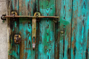 Eski, yeşil, çelikle döşenmiş çiftlik binaları için ahşap kapılar. Kötü ışıklandırma koşulları