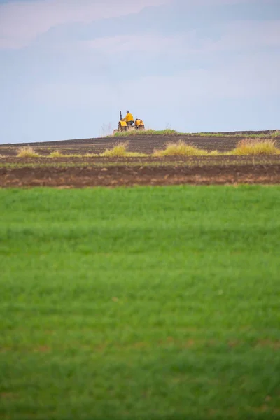 Çiftçi Gökyüzünün Arka Planına Karşı Sarı Bir Traktör Üzerinde Çalışıyor — Stok fotoğraf