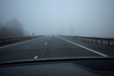 Driving in foggy weather on the highway. Driving in autumn and winter weather.