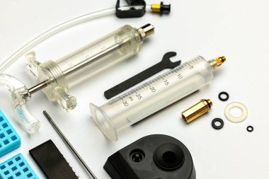 Hidrolik bisiklet freni kanaması ve yağ değiştirme kiti. Beyaz arka planda hidrolik fren hizmeti araçları. Fotoğraf, el feneriyle çekildi.