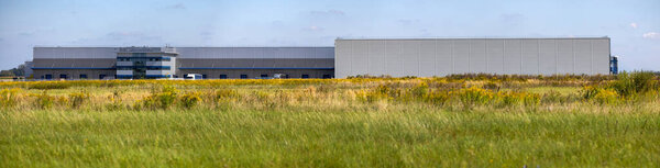 Отдаленный вид на склад логистического центра. Фото сделано в солнечный день.