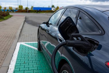 Otoyol dinlenme noktasında koyu mavi elektrikli yolcu vagonunun şarjı. Şarj prizinin ayrıntıları.