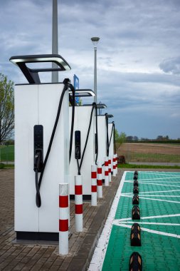 Benzin istasyonunun otoparklarındaki elektrikli araba şarj istasyonları. Alternatif araç sürüş sistemleri.