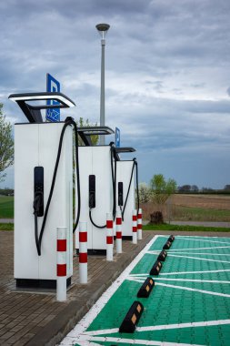 Benzin istasyonunun otoparklarındaki elektrikli araba şarj istasyonları. Alternatif araç sürüş sistemleri.