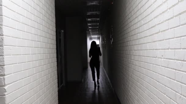 Silhouette di una donna che danza sensualmente all'ombra nel lungo corridoio bianco — Video Stock