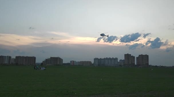 SAINT PETERSBURG, RUSLAND - 26 juli 2019 Helikopter nadert landing in groene duivel. Mensen kijken toe.. — Stockvideo