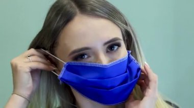 Kadın, koronavirüs salgınından korunmak için mavi maske takıyor.