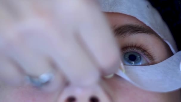 Nahaufnahme Kosmetologe legt Augenklappen auf Frau i vor Wimpernverlängerungen — Stockvideo