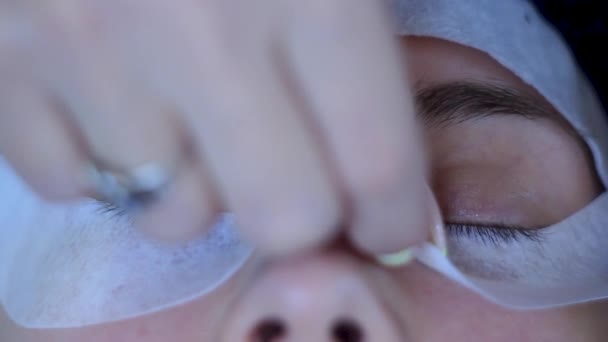 Primer plano cosmetólogo ajusta parches en los ojos de la mujer antes de las extensiones de pestañas — Vídeos de Stock