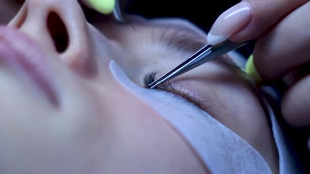 Close up cosmetologist coloca pestanas extensões na mulher branca, procedimento de beleza — Vídeo de Stock