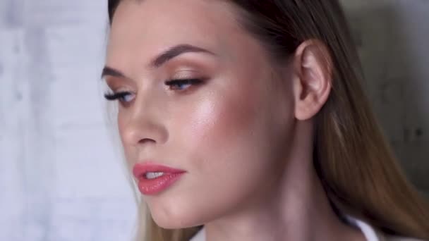 Närbild Ung blond kvinna med makeup vända åt sidorna, visar upp makeup — Stockvideo