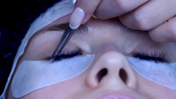 Cosmétologue de près met des extensions de cils sur la femme, touches de finition — Video