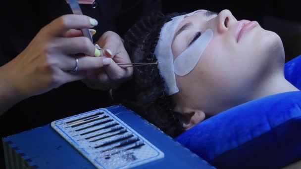 Cosmetologue en masque rose met des extensions de cils sur la femme blanche, procédure de beauté — Video