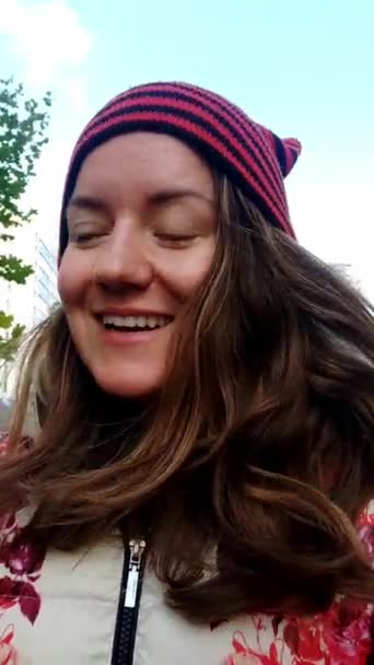 POV Young woman in hat without makeup walking on a street and recording video — Stock Video