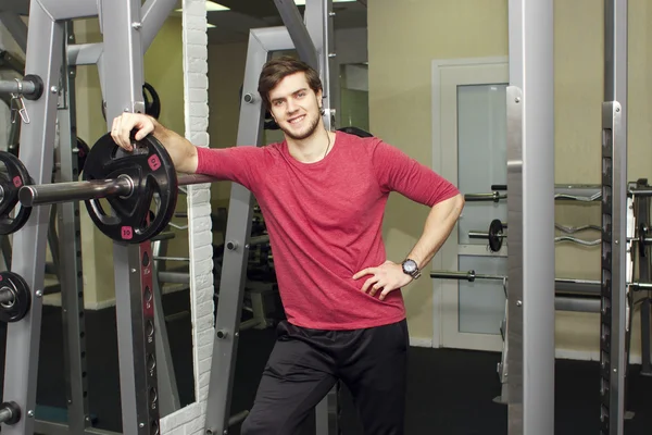 Fitness athletic trainer shows exercises with foarm roll, ball in gym.