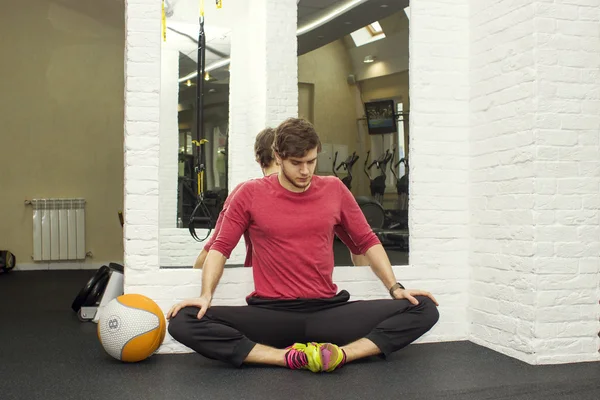 Trener fitness lekkoatletycznego pokazuje, ćwiczenia z foarm rolki, piłki w siłowni. — Zdjęcie stockowe