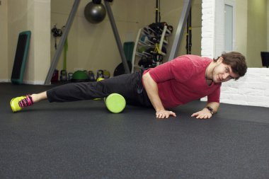 Egzersizleri foarm ile rulo, top spor salonunda Fitness Spor eğitmeni gösterir.