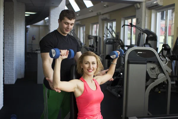 Couple de fitness s'entraîner avec haltères dans la salle de gym — Photo
