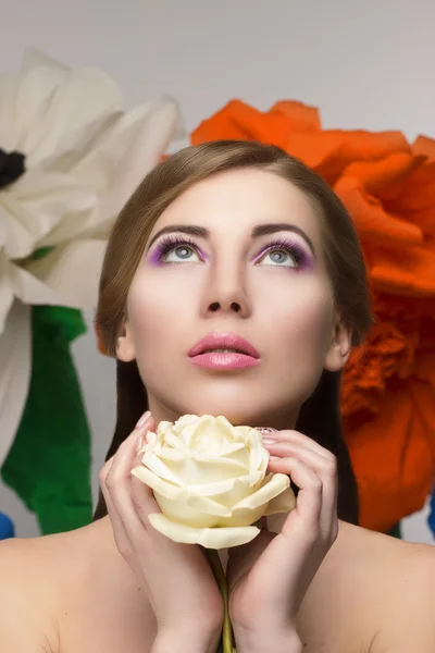 Retrato de menina de beleza com maquiagem brilhante segurar rosa em mãos — Fotografia de Stock