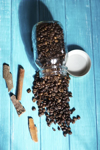 Café en botella sobre mesa de madera sobre fondo azul — Foto de Stock