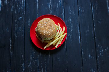 Fast food büyük hamburger ve patates kızartması siyah arka plan üzerine ayarla