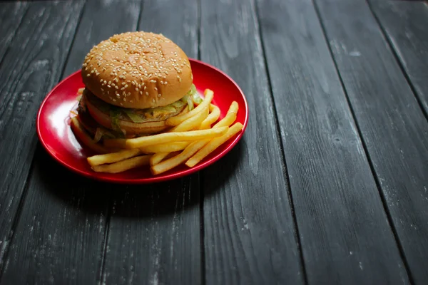 Fast food büyük hamburger ve patates kızartması siyah arka plan üzerine ayarla