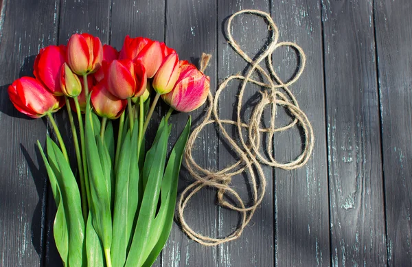 Red tulips on rustic wooden table. Top view with copy space — Stock Photo, Image