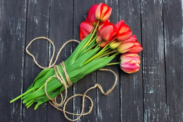 Red tulips on rustic wooden table. Top view with copy space — Stock Photo, Image