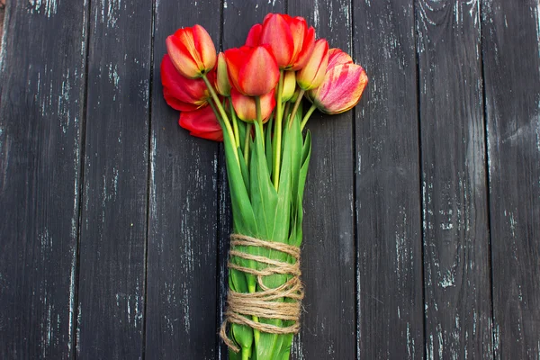 Tulipanes rojos sobre mesa rústica de madera. Vista superior con espacio de copia —  Fotos de Stock