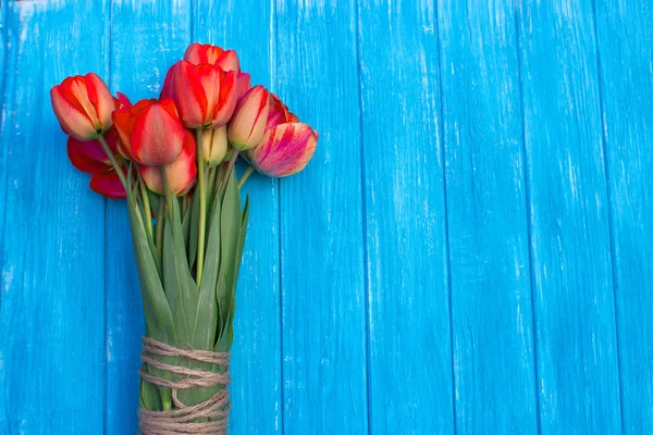Kolorowe tulipany na cyjan drewniany stół. Widok z góry z kopii przestrzeni — Zdjęcie stockowe