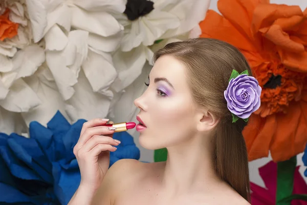 Güzel bir kadın kırmızı ruj dudakları boyar ve resimde görünüyor