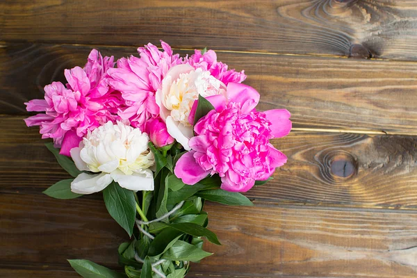Many beautiful colored peonies on wooden background — Stock Photo, Image