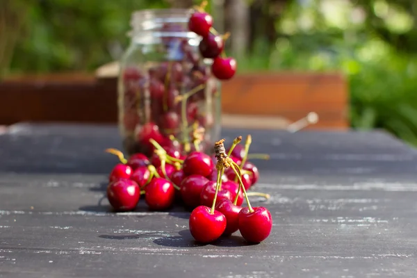 Las jugosas y sabrosas cerezas rojas yacen sobre una mesa de madera — Foto de Stock