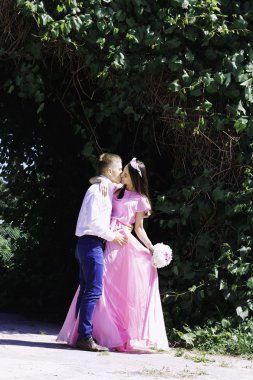 çok güzel bir elbise genç gelin damat bir buket çiçek ile bir düğünde kucaklayan