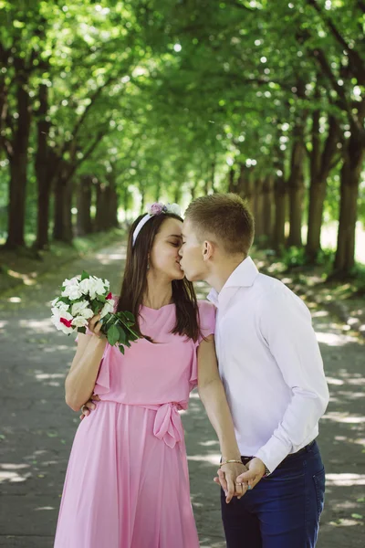 Newlyweds tseltsyutsya in the park — Stock Photo, Image