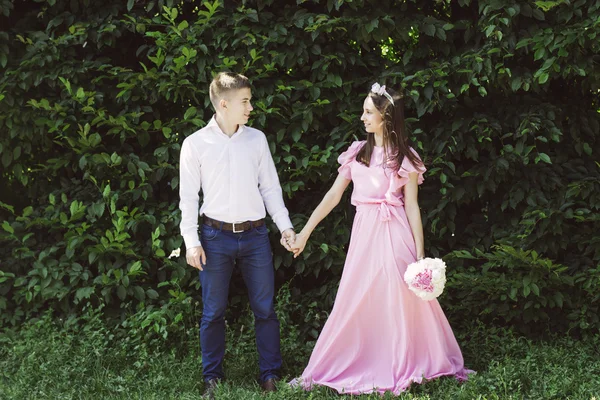 The young bride in a beautiful dress groom holds the hand at the wedding — Stock Photo, Image