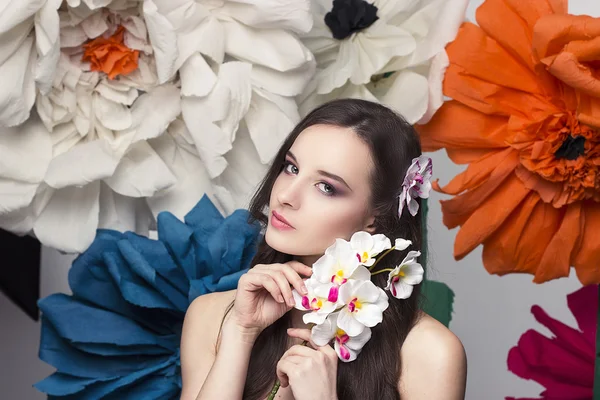 Retrato de beleza de um modelo com uma coroa de flores na cabeça, segurando um buquê de rosas e maquiagem bonita — Fotografia de Stock