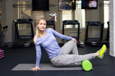 beautiful blond athletic girl in a gym doing exercises