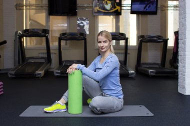 beautiful blond athletic girl in a gym doing exercises
