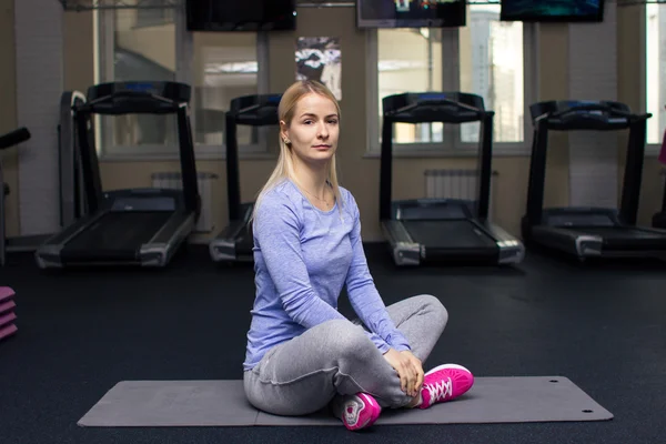 Beautiful blond athletic girl in a gym doing exercises — Zdjęcie stockowe