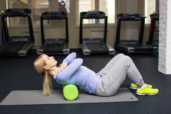 beautiful blond athletic girl in a gym doing exercises