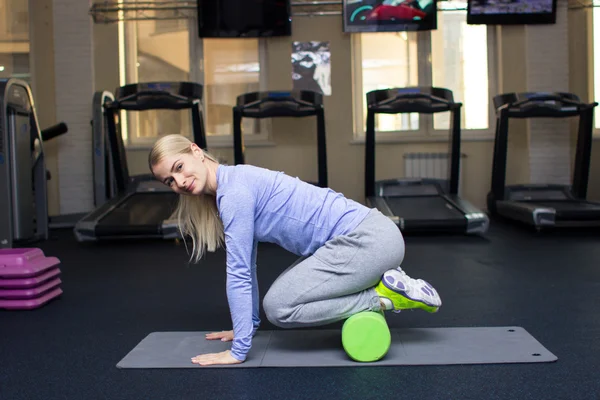 Beautiful blond athletic girl in a gym doing exercises — Zdjęcie stockowe