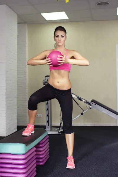 Fitness trainer shows the technique exercises with a pink fitness ball yoga — 스톡 사진