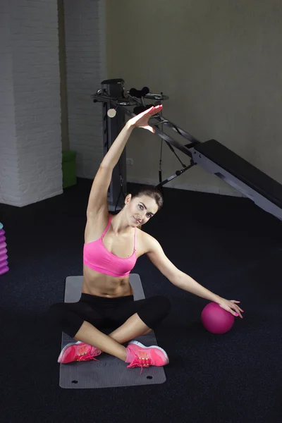 Fitness trainer shows the technique exercises with a pink fitness ball yoga — Zdjęcie stockowe