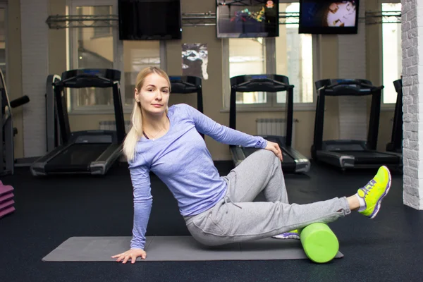 Beautiful blond athletic girl in a gym doing exercises — Zdjęcie stockowe