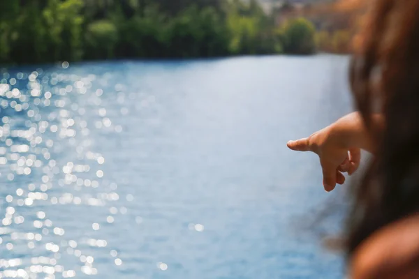 Ponto de mão mulher no lago azul — Fotografia de Stock